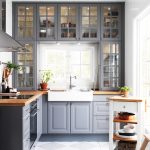 Cocina con paredes blancas y muebles grises.