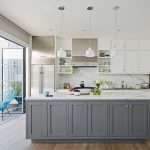 Interior de cocina blanco con mesa gris isla
