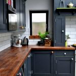 Muebles de cocina gris oscuro con encimera de madera