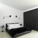 Interior de dormitorio blanco con armario negro.