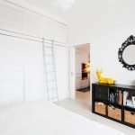 Espejo con borde negro en el interior del dormitorio blanco