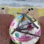 En la parte superior de la pelota, comenzamos a colocar ramas de manera caótica, pegándolas suavemente entre sí.