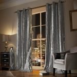 Mesita de noche con una lámpara junto a la ventana