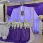 Mantel blanco y lila sobre una mesa de boda