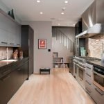 Área de trabajo en la cocina con un televisor en la pared.