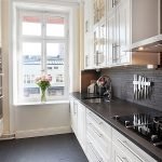 Delantal negro y muebles blancos en la cocina.