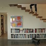 Estanterías debajo de los escalones en el pasillo