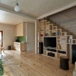 TV y estanterías debajo de las escaleras