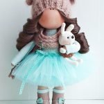 Conejito en las manos de una muñeca