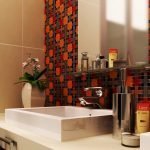 Espejo en la pared con mosaico en el baño.