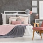 Paredes grises y textil rosa en el dormitorio