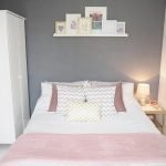 Colcha rosa en una habitación gris