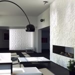 Una mesa y un sofá frente a una chimenea decorativa.