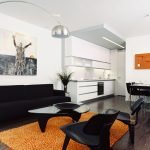 Muebles negros y alfombra naranja en la sala de estar.