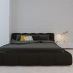 Cama oscura en un interior blanco.
