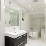 Muebles negros en un baño luminoso.
