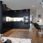 Cocina negra en un interior blanco.