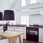 Mesa de madera en el interior de una cocina blanca
