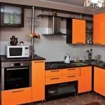 Elegante cocina en negro y naranja.