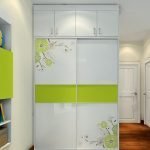 Armario corredizo blanco con decoración verde.