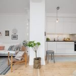 Muebles blancos y un refrigerador oscuro en la cocina.