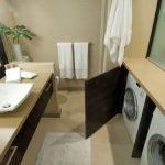 Lavadora detrás de la puerta en el baño