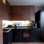 Muebles de cocina negros en un interior blanco.