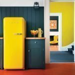 La combinación de una pared gris y un refrigerador amarillo.
