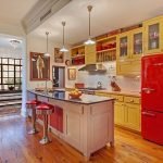Una combinación de muebles de mostaza y un refrigerador rojo.