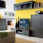 La combinación de muebles oscuros y la pared amarilla.