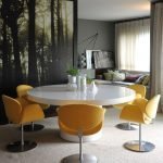 Sillones amarillos con patas alrededor de una mesa blanca