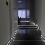 Pasillo con paredes claras y piso oscuro.