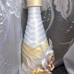 Champán con cintas blancas y doradas