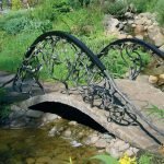 Puente de hormigón con barandilla de hierro.