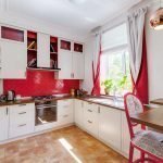 Cocina blanca con delantal rojo