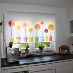 Macetas de flores en una cortina en la cocina