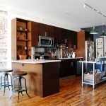 Muebles de cocina de madera oscura con microondas integrado.