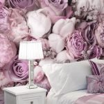 Mesita de noche blanca con lámpara junto a la cama