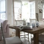 Sillas blancas junto a la mesa de madera.