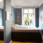 Cama junto a la ventana en una habitación pequeña