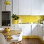 La combinación de muebles blancos y un delantal amarillo.