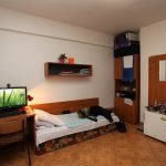 Escritorio con computadora junto a la cama