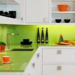 La combinación de muebles blancos y delantal verde claro.