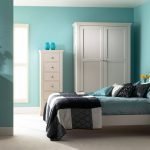 La combinación de paredes turquesas y muebles blancos en el dormitorio.