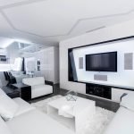 Sofá esquinero blanco y una mesa frente al televisor