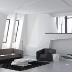 Sofá gris y sillón en un interior blanco.