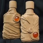 Piedras rojas en botellas beige