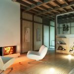 Sillones blancos junto a la chimenea decorativa.