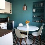 Sillas blancas y una mesa en un interior turquesa