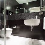 Diseño de baño en negro con piso blanco.